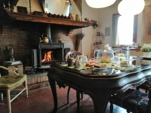 a table with food on it in a kitchen with a fireplace at Corte di Maggio B&B in Imola