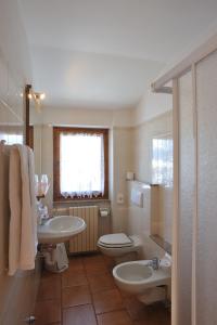 ヴァルディソットにあるHotel Ristorante San Pietroのバスルーム(洗面台、トイレ付)、窓が備わります。
