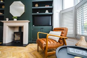 a living room with a chair and a television at Best Stays York - Bishy Road Abode in York