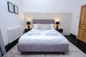 a bedroom with a large white bed with towels on it at Best Stays York - Bishy Road Abode in York