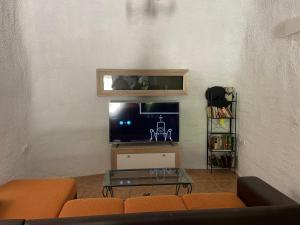 a living room with a couch and a tv at Cortijo casa rural "La cueva " in Almería