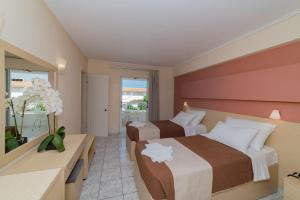 una camera d'albergo con due letti e una finestra di Roseland Hotel a Kalamákion