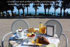 a table with a breakfast of coffee and food on it at Amare Sirolo in Sirolo +19 photos