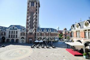 a large building with a clock tower in a city at Piazza Four Colours in Batumi