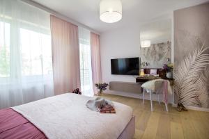 a bedroom with a bed and a flat screen tv at W&K Apartments - Glam Suite in Koszalin