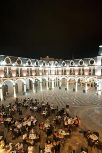 a large building with people sitting at tables at night at Piazza Four Colours in Batumi