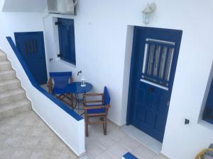 a hallway with a blue door and a table and chairs at Asimina Studios in Donoussa