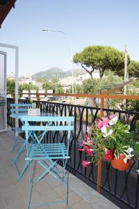 balcón con mesa, sillas y flores en Vesuvius' Lovely Inn, en Ercolano