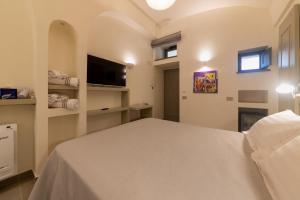 a bedroom with a white bed and a tv at Insula Boutique Hotel in Procida
