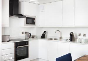 una cocina blanca con armarios y electrodomésticos blancos en We Love HU en Hull