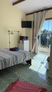 1 dormitorio con 1 cama en una habitación con ventana en Suíte Ninho do Sabiá, en Ilhabela