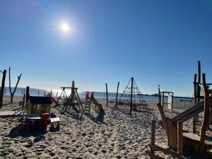 a beach with a swing set on the sand at Apartament Diamentowy w Sopocie in Sopot