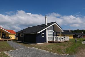 een klein huis met een zwart dak bij Resort 2 Ocean Cottage A 16 in Großenbrode