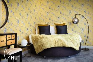a bedroom with a bed with a yellow wall at We Love HU in Hull