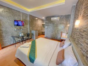 una camera con un grande letto bianco di โรงแรมโทนี่วิลเลจTony Hotel a Phatthalung