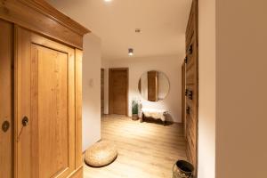 a hallway with a wooden door and a mirror at Alpen-Lounge Apartment 17 Zillertal in Fügen