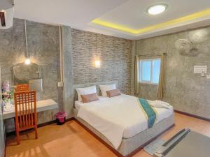 una camera con letto e scrivania di โรงแรมโทนี่วิลเลจTony Hotel a Phatthalung