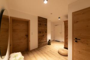 a room with wooden doors and wooden floors at Alpen-Lounge Apartment 17 Zillertal in Fügen +29 photos