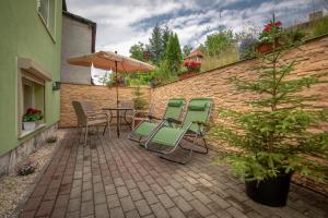 a patio with a table and chairs and an umbrella at Apartament LUIZA in Lądek-Zdrój