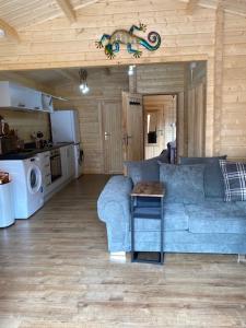 a living room with a blue couch and a kitchen at The WOODEN LODGE NO 1 AT THE BALTIC CAINS BREWERY in Liverpool