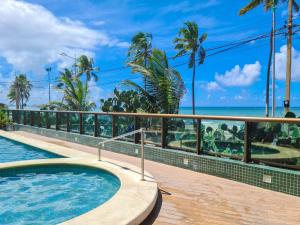 a swimming pool with a view of the ocean at Ritz Suites Maceió Flat particular Temporada in Maceió