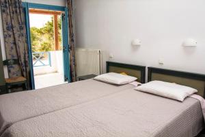 1 dormitorio con 1 cama con 2 almohadas y ventana en Villa Irida, en Psari Forada