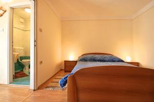 a bedroom with a bed and a bathroom with a toilet at Apartments Bazjak in Livade