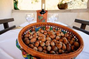 een mand noten op een tafel met twee wijnglazen bij Apartments Bazjak in Livade