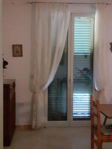 a room with a window with curtains and a door at BED & BREAKFAST Villa Cerasa in Case del Bevano