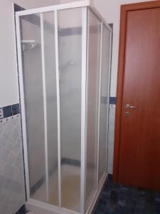 a glass shower stall next to a wooden door at BED & BREAKFAST Villa Cerasa in Case del Bevano