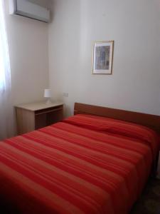 a bedroom with a red bed with a red blanket at BED & BREAKFAST Villa Cerasa in Case del Bevano