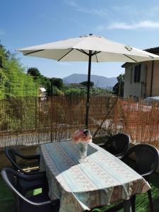 een tafel met een vaas met bloemen en een paraplu bij GINEVRA in La Spezia