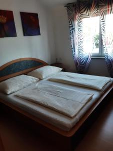2 Einzelbetten in einem Schlafzimmer mit Fenster in der Unterkunft Apartmani Franka in Rovinjsko Selo