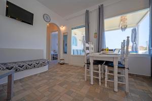 a living room with a table and chairs and a tv at Molos Sea View House - Paros Greece in Molos Parou