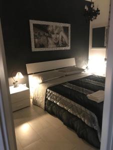 1 dormitorio con 1 cama con una foto en la pared en La maison de Medea, en Pulsano