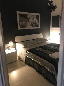 a bedroom with a bed with a picture on the wall at La maison de Medea in Pulsano