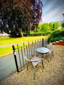 a table and chairs sitting next to a fence at Modern ground floor apartment with free parking very near centre in Ripon
