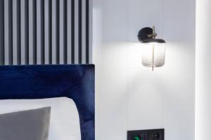 a room with a bed and a light on a wall at Kayus in Buşteni