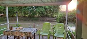 una mesa y sillas en un porche con vistas al río en Tarmtawan garden home en Nakhon Nayok