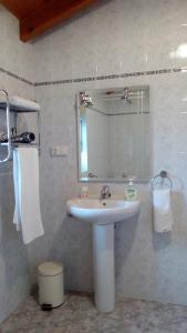uma casa de banho com um lavatório branco e um espelho. em La Casa de Consuelo 3 em Viérnoles