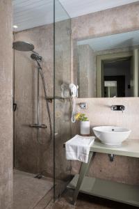 a bathroom with a sink and a glass shower at The G Hotel in El Alamein