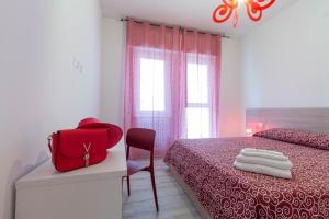 un dormitorio con una bolsa roja sentada en una cama en Le Casette Di Osvaldo, en Lecco
