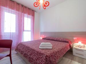 a bedroom with a bed with a red bedspread at Le Casette Di Osvaldo in Lecco