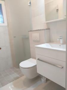 ein weißes Bad mit einem WC und einem Waschbecken in der Unterkunft Sandy apartment in Nin