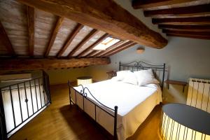1 dormitorio con 1 cama en una habitación con techos de madera en Colle al Matrichese - Historic Winery, en Montalcino