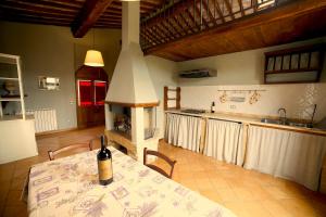 a kitchen with a table with a bottle of wine on it at Colle al Matrichese - Historic Winery in Montalcino