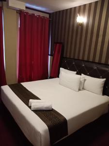 a bedroom with a large bed with a red curtain at HOTEL SRI IMPIAN in Johor Bahru