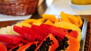 un plato de fruta en rodajas sobre una mesa en Pousada El Parador en Búzios