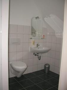a bathroom with a toilet and a sink at Wersauer Hof - Ferme Auberge in Reilingen