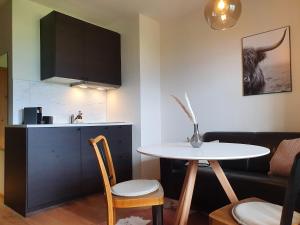 a living room with a table and a kitchen at Gruberwirt Apartments in Innsbruck